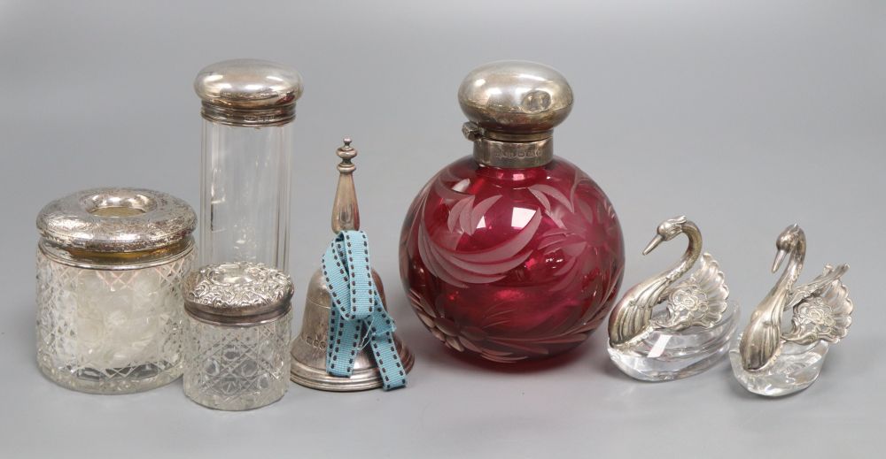 A collection of silver to include scent and toilet bottles, dressing table jars with silver tops, a pair of cut glass swan salts, a tab